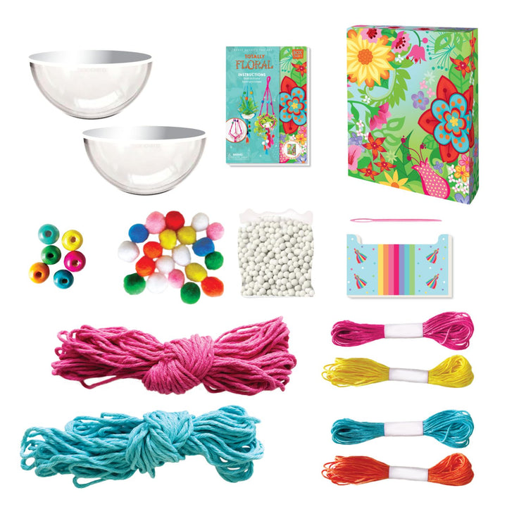 Out of bo image of Totally Deco! Make your Own Macrame Plant hangers  which shows its content that Includes: 2 plastic plant bowls, 2 rolls macrame yarn, 4 colors of crafting twine, 1 child-safe crafting needle, 1 bag white clay stones, 6 wooden beads, flexible threading wire, 1 cardboard tassel maker, 20 colored pompoms and instructions, all in a keepsake storage box made from recycled cardboard.