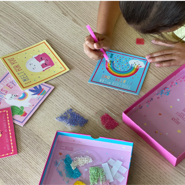 Lifestyle image of child decorating rainbow image with Totally Deco! Diamond Art Set.