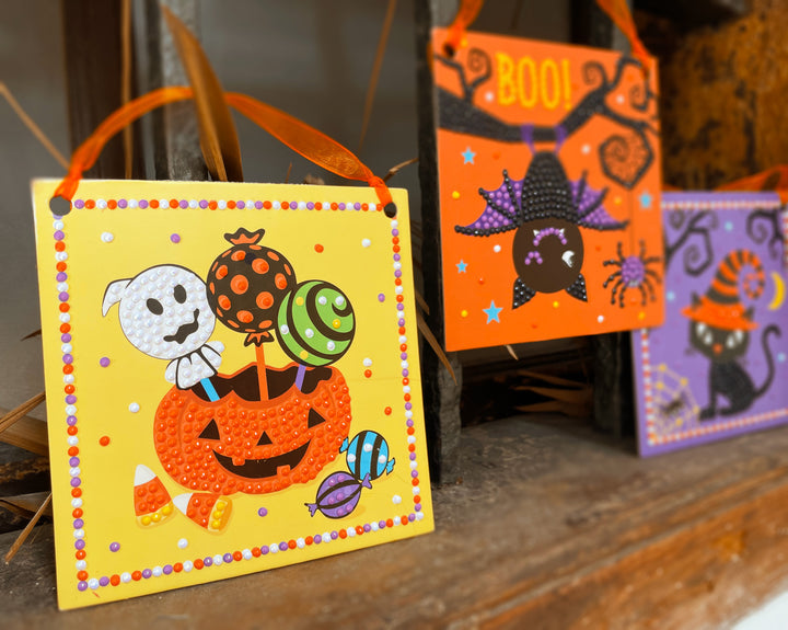 Image of the pumpkin candy, bat, and cat completed halloween diamond art set. 