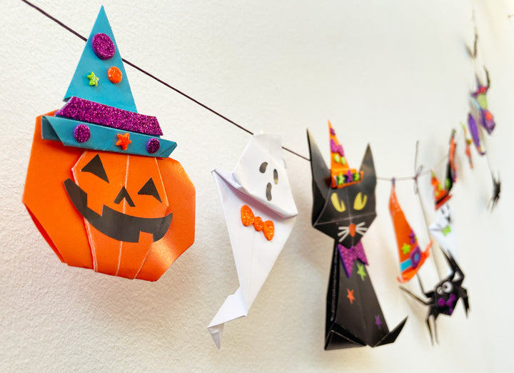 Image of the completed halloween origami garland hanging on the wall. 