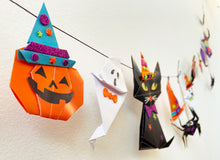 Load image into Gallery viewer, Image of the completed halloween origami garland hanging on the wall. 
