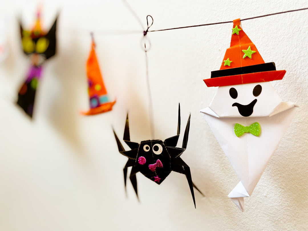 Image of the completed halloween origami garland hanging on the wall.