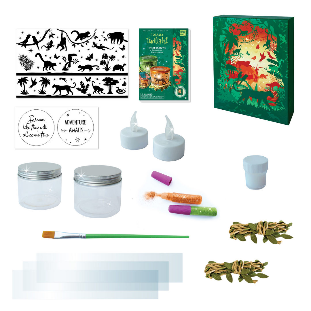 Image of the materials inside of the rainforest night light jar set which Includes: 2 plastic jars, 2 flameless LED candles with batteries, 2 tubes of powder glitter, 3 sheets of transparent paper, 2 sticker sheets, 2 decorative rainforest vines, 1 brush, 1 container of glue and instructions, all in a keepsake storage box made from recycled cardboard.