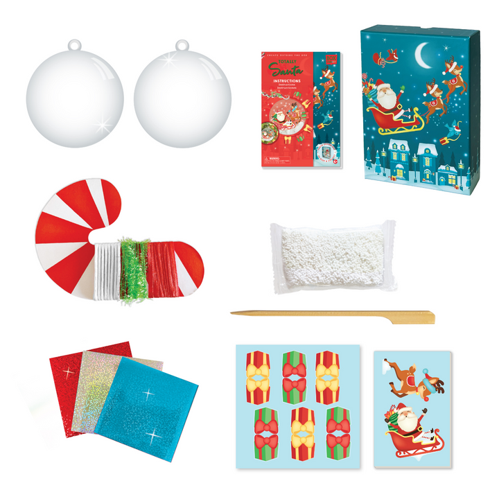 image of the materials which Includes: 1 (3.5 inch) clear ornament ball, white play foam “snow”, cardboard press out figures, decorative candy cane roll with 3 assorted ribbons and strings, 1 wooden craft stick, 3 colored foil sheets, glitter stickers and instructions, all in a beautiful keepsake storage box made from recycled cardboard.