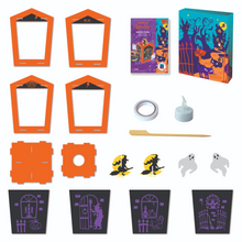 Load image into Gallery viewer, Image of the materials inside of the haunted house lantern scratch art set which Includes: 4 artboard scratch cards with haunted scenes, 1 wooden craft stick, 10 cardboard puzzle pieces to build a 3D lantern with characters, 1 flameless LED candle with battery, 1 roll of double sided tape, and instructions, all in a keepsake storage box made from recycled cardboard.
