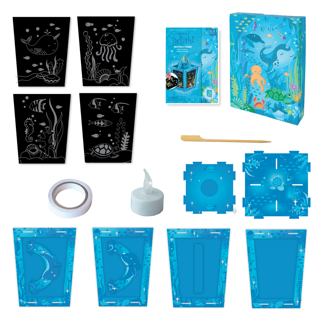 Image of the material which Includes: 4 artboard scratch cards with 4 enchanting underwater scenes, 1 wooden craft stick, 9 cardboard puzzle pieces to build a 3D lantern, 1 flameless LED candle with battery, 1 roll double-sided tape and instructions, all in a beautiful keepsake storage box made from recycled cardboard.