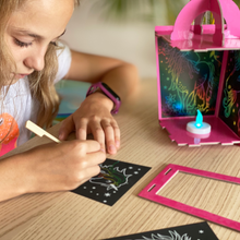 Load image into Gallery viewer, Lifestyle image of a child scratching on a unicorn lantern scratch art set.  Edit alt text

